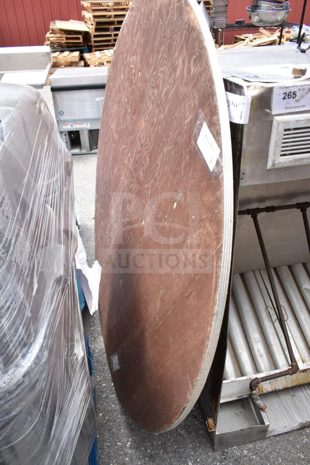 Round folding table, wooden surface, dimensions 58x58x3 inches. Visible wear and minor scratches. Auction label attached.