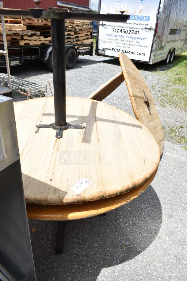 Outdoor display of two wood tables and three table tops, showing wear. Label indicates item 117422.