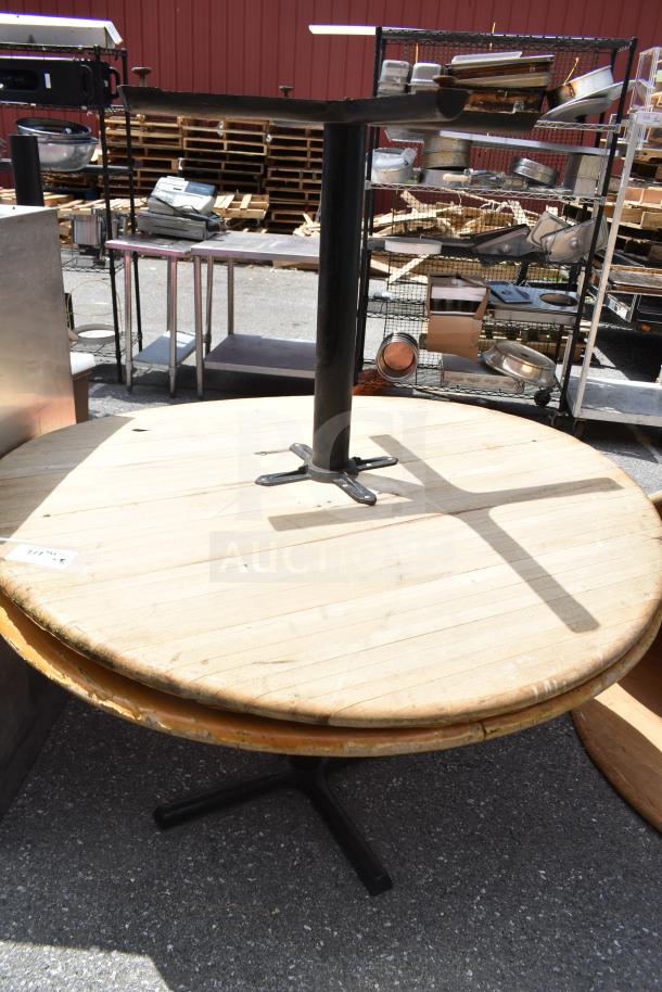 Five items: two metal tables and three wooden table tops in used condition, visible number tag indicating auction lot.