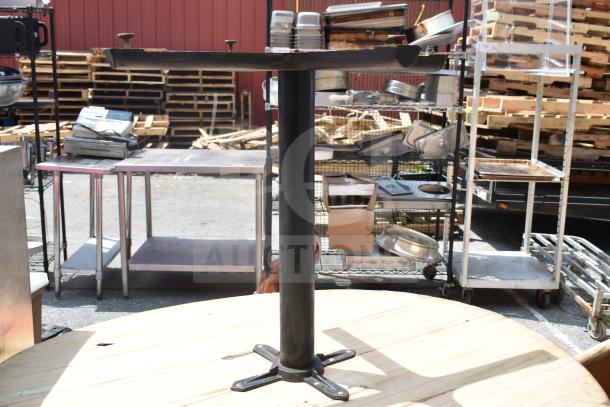 Five items including two tables and three table tops, in used condition, displayed outdoors with industrial surroundings.