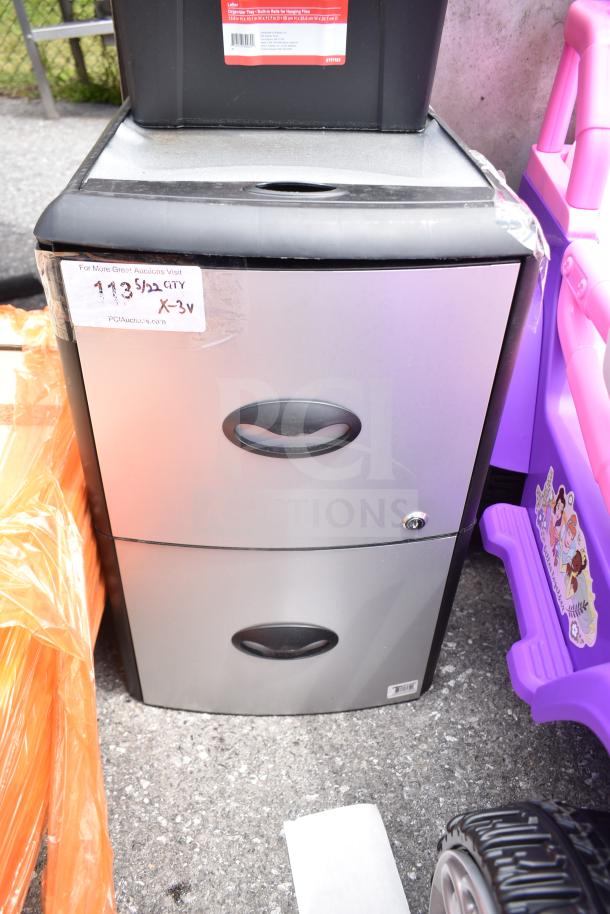 Two-drawer metal cabinet with black handles, portable file tote on top, and sticker label. Item in good condition.
