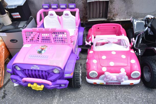 Two children's ride-on vehicles: Disney Princess purple car with two seats, and Minnie Mouse pink car with polka dots.
