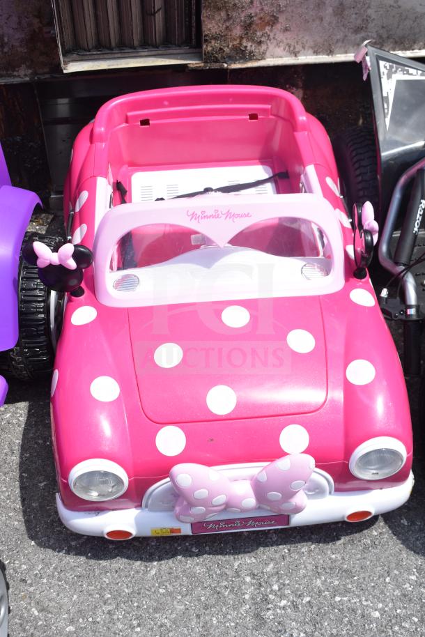 Disney Princess purple and Minnie Mouse pink children's ride-on cars with white polka dots, good condition.