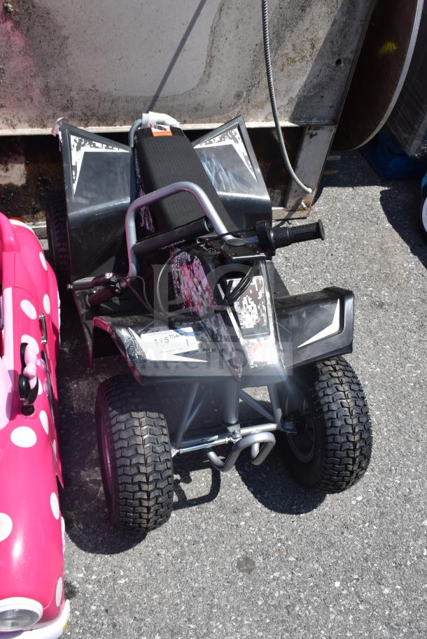 Children's ride-on ATV with black and white design, sturdy tires, and handlebar controls. Appears in good condition.