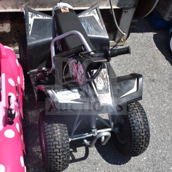 Children's ride-on ATV with black and white design, sturdy tires, and handlebar controls. Appears in good condition.
