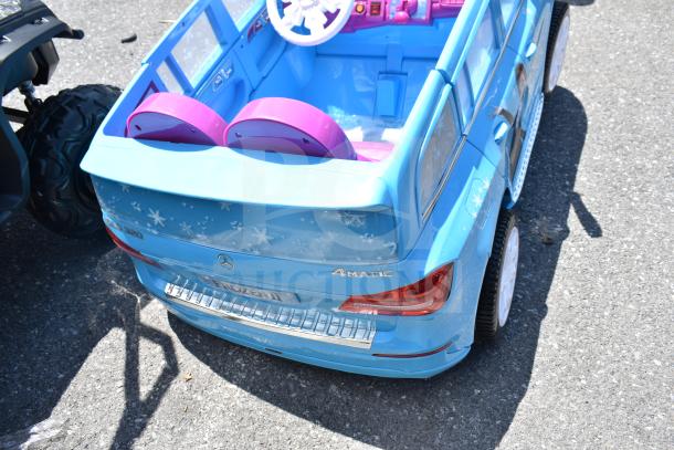 Blue Frozen II themed Mercedes ride-on toy car for children, featuring pink seats, snowflake decals, and Mercedes branding.