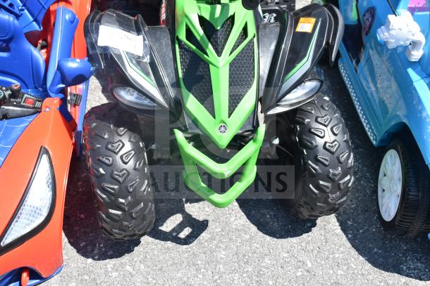 Ride On Children's Raptor ATV with green and black design, rugged tires, and front grill. Good condition. Tags visible.