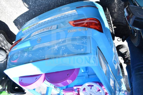 Blue children's Mercedes ride-on car, Frozen II theme, featuring snowflake decals, trunk design, and realistic details.
