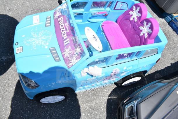 Blue Frozen II Mercedes ride-on toy car for children, featuring Elsa graphics. Pink seats with snowflakes, in good condition.
