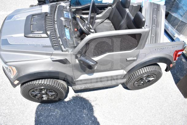 Ride On Children's Ford Gray Car, features detailed interior, rugged tires, "Raptor" and "F-150" decals, in good condition.