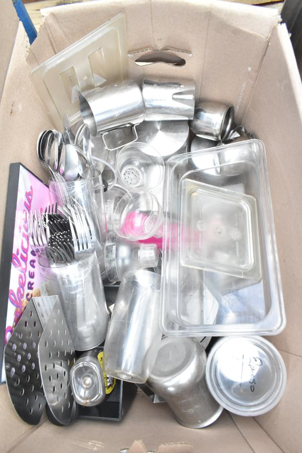 Box of assorted items including metal cups, cutlery, and plastic containers. Items are in used condition.
