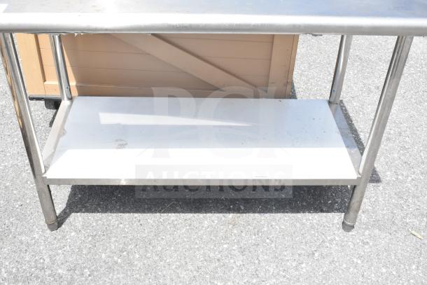 Commercial table with under shelf, stainless steel frame, used condition, white under shelf for added storage.