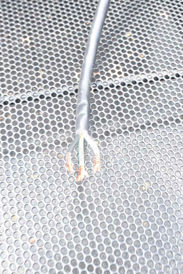 Killion Commercial Merchandiser power cord, exposed wire ends, on a textured metal surface. Signs of wear visible.
