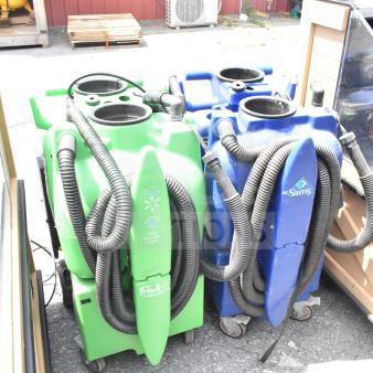 Two floor cleaning machines on wheels, one green and one blue, with hoses. Green machine branded "Fresh Operations."