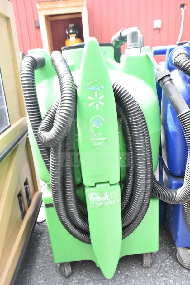 Two floor cleaning machines, green and blue, labeled "Walmart Case Cleaning Cart," with attached hoses; used condition.