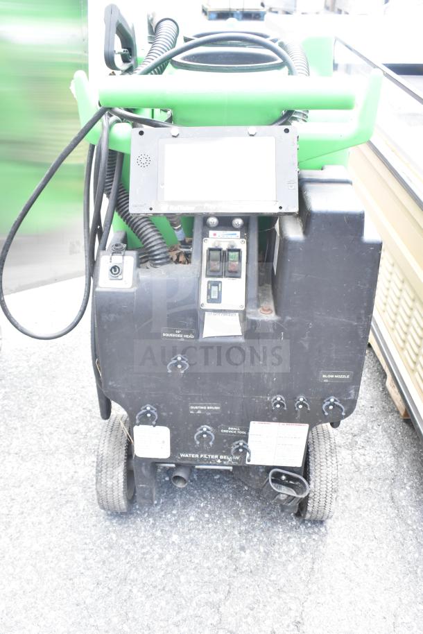 Two floor cleaning machines with control panel, hoses, and wheels. Features include squeegee head and water filter. Good condition.