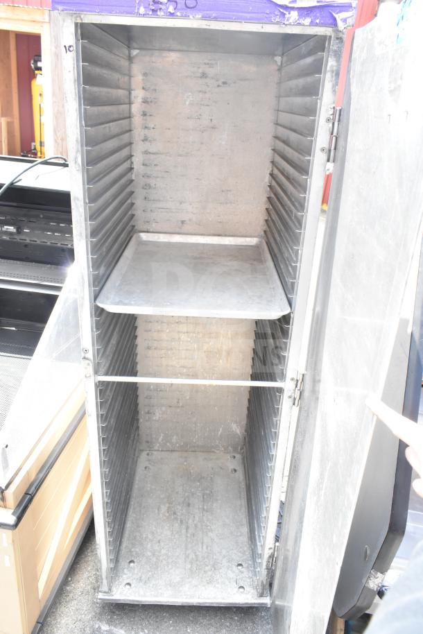 Commercial enclosed pan transport rack on casters, metal construction, used condition, interior shelving, open door view.