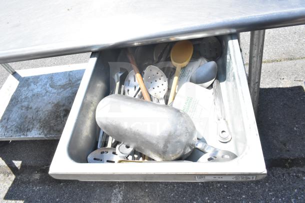 Commercial table with under shelf, two drawers on casters; drawer contains various utensils. Used condition.