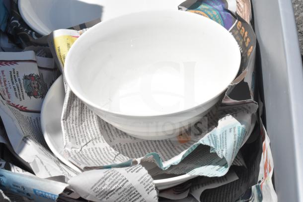 Two boxes containing various items, including white porcelain bowls and plates, wrapped in newspaper, auctioned 2x bid.