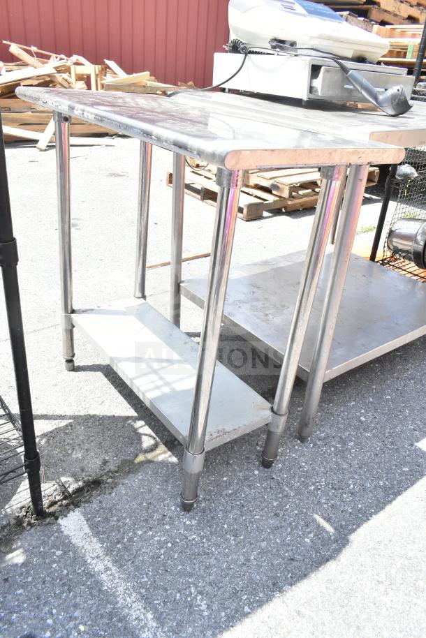 Chrome commercial table with under shelf, sturdy construction, showing signs of use. Ideal for kitchen or retail use.