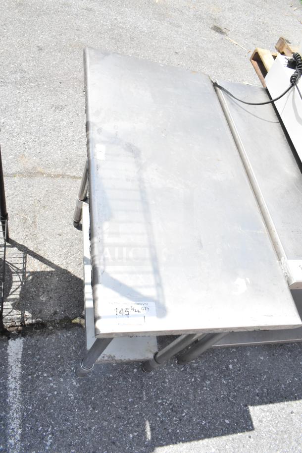 Commercial metal table with under shelf, durable build. Visible wear. Tag indicates auction ID 145 with quantity info.