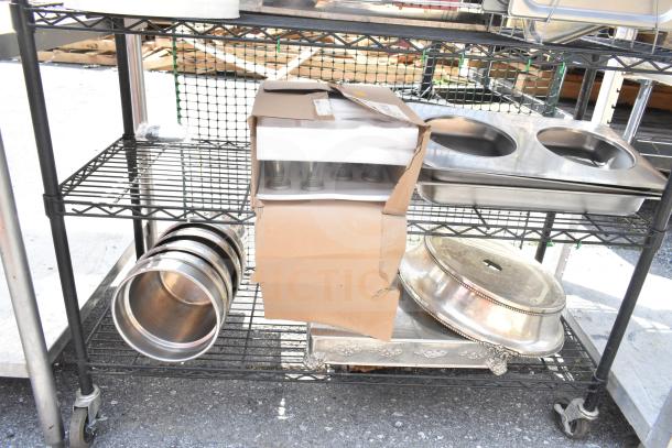 Chrome and black 6-tier wire shelving unit with assorted items, including trays and containers. Buyer must dismantle.