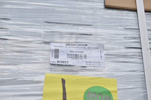 BRAND NEW SCRATCH AND DENT! Regency 600SMC48DDM 48" stainless steel mop sink cabinet in packaging with product label visible.