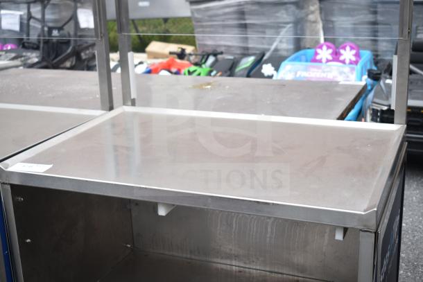 Commercial cart with under shelf, on commercial casters. Stainless steel, used condition, suitable for industrial use.
