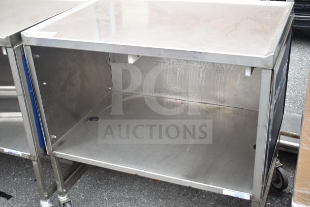 Commercial stainless steel cart with under shelf and commercial casters. Features durable construction, used condition.