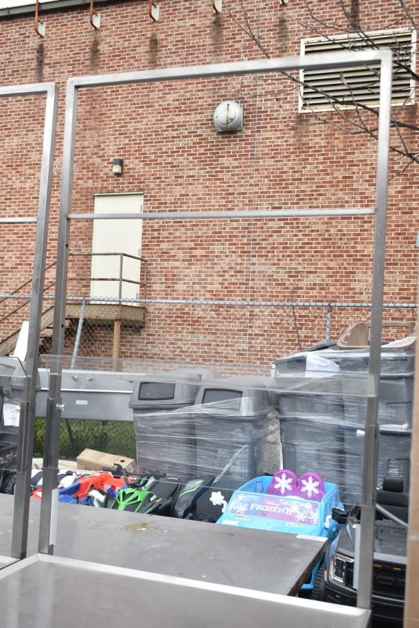 Commercial cart with under shelf on heavy-duty casters, metal frame, outdoor setting, minor wear visible.