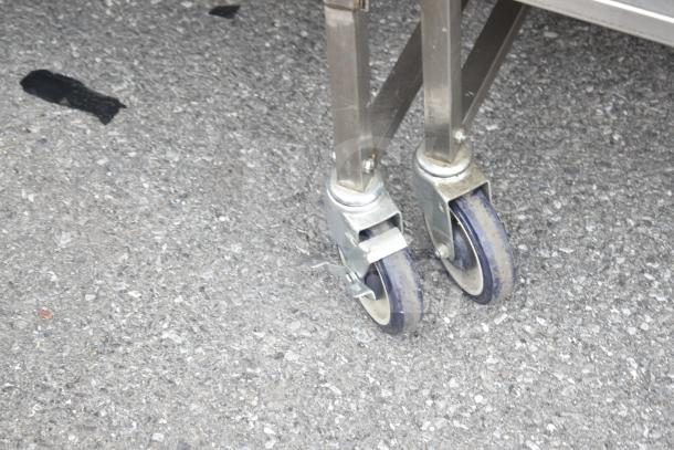 Commercial cart with under shelf on durable commercial casters, metal frame. Suitable for heavy-duty use.