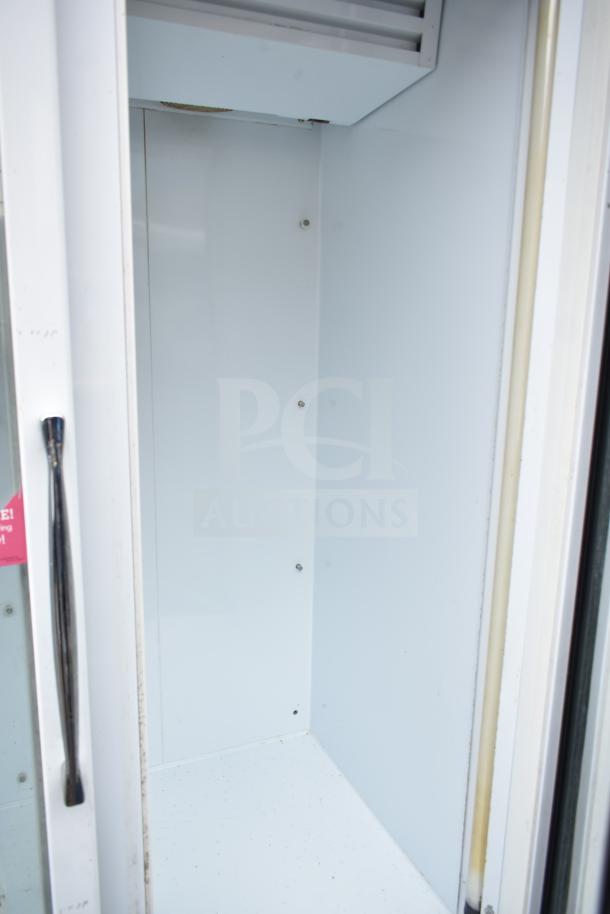 National ULG80BCP-6 commercial 3-door freezer, interior view, shows white walls and shelving slots, clean condition.