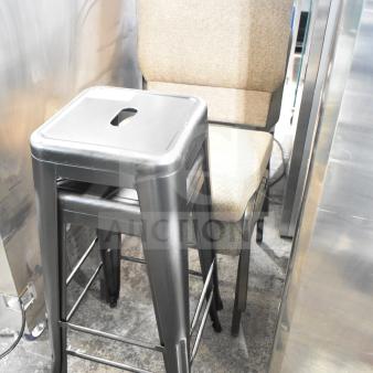 Four furniture items including two metal bar stools and two upholstered chairs. Bar stools have a black finish.