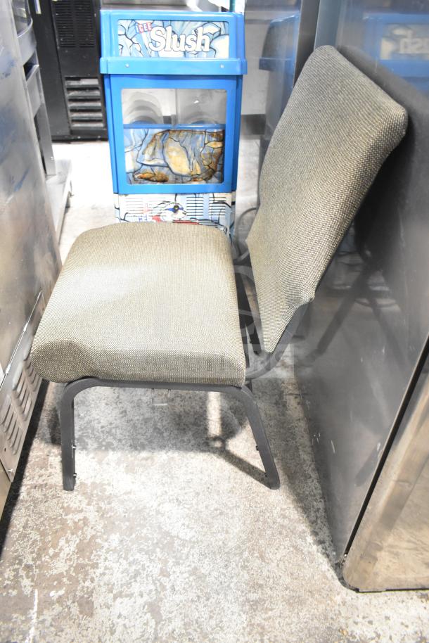 Gray upholstered chair with metal frame, next to a blue Icee Slush machine. Part of an auction lot with 4 seating items.