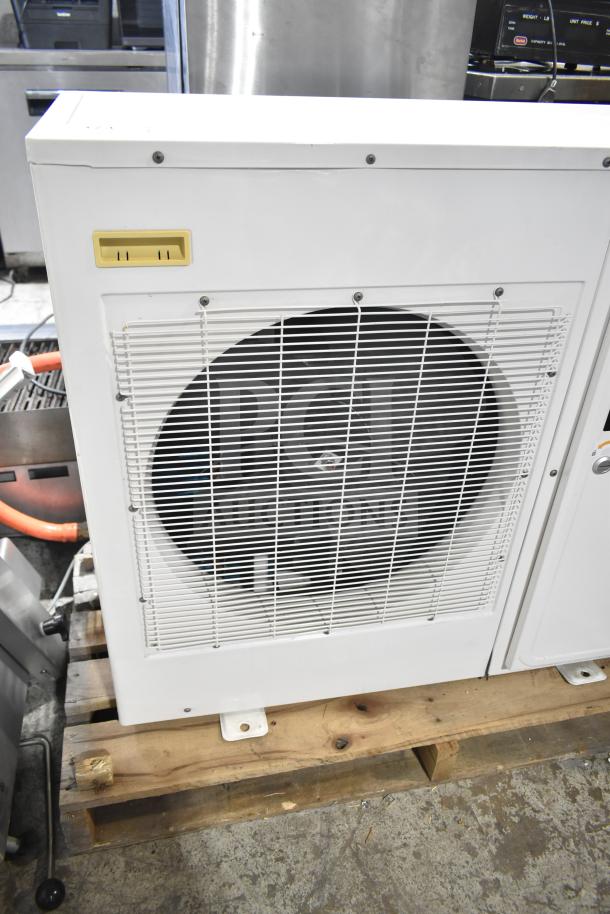 Copeland XFAM-010Z-TFC-081 condensing unit, 208-230V, 3 phase. White casing, fan grill visible, on a wooden pallet.