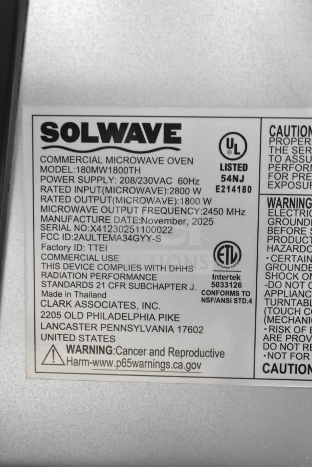 Label on Solwave 180MW1800TH commercial microwave indicating model, power supply, manufacture date (Nov 2025), and safety compliance.