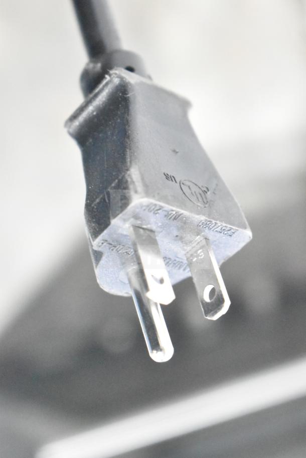 Cadco Unox XAFT133-US convection oven plug for 208-240V, 1 phase. Close-up showing prongs and markings.
