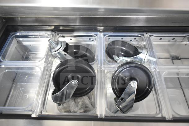 BRAND NEW True TSSU-60-16D-4-HC sandwich prep table with visible caster wheels in clear food pans, 115V, 1 phase.