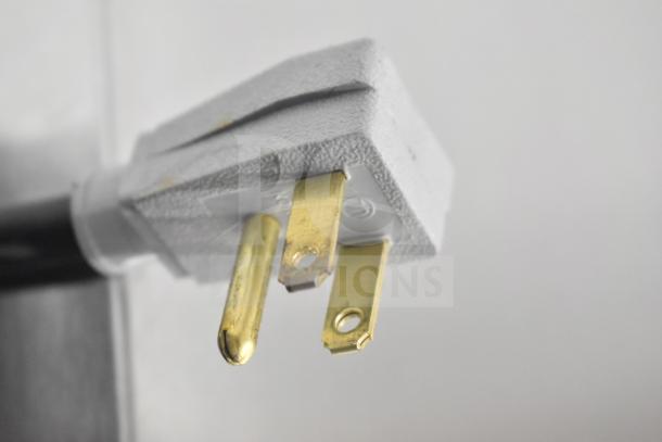Close-up of a 115-volt plug for the True TSSU-60-16D-4-HC commercial prep table, showing electrical prongs.