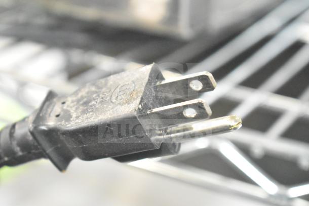 Close-up image of a power plug, likely for the 2022 Sharp R-21LVF Commercial Countertop Microwave Oven, 120 volts, 1 phase.