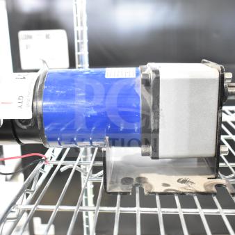100ZYT51-GK60 motor, 130 volts, 1 phase, blue casing, wires attached, mounted on a shelf, label indicates specifications.