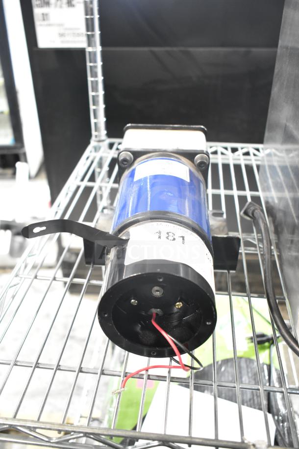 100ZYT51-GK60 motor, 130 volts, 1 phase, blue casing, mounted on a metal rack, visible wiring and label details.