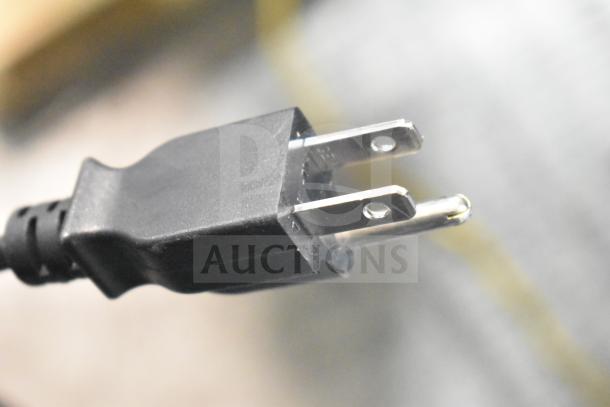 Close-up of a power plug for a Hobart HTi-7LH4W food portioning scale, featuring a standard two-prong design.