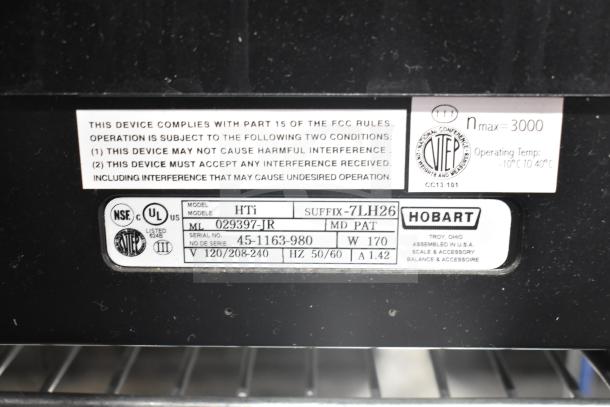 2017 Hobart HTi-7LH26 scale label showing model, voltage, and compliance details. Screen damage noted. No power cord included.