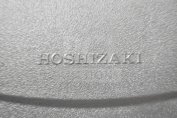"Textured surface with embossed 'Hoshizaki' logo on the 2024 KM-231BAJ ice machine, new scratch and dent condition."