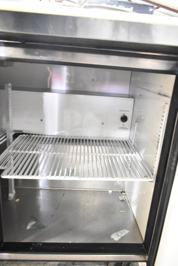 True TSSU-48-08 Commercial Sandwich Salad Prep Table interior, featuring stainless steel shelving.