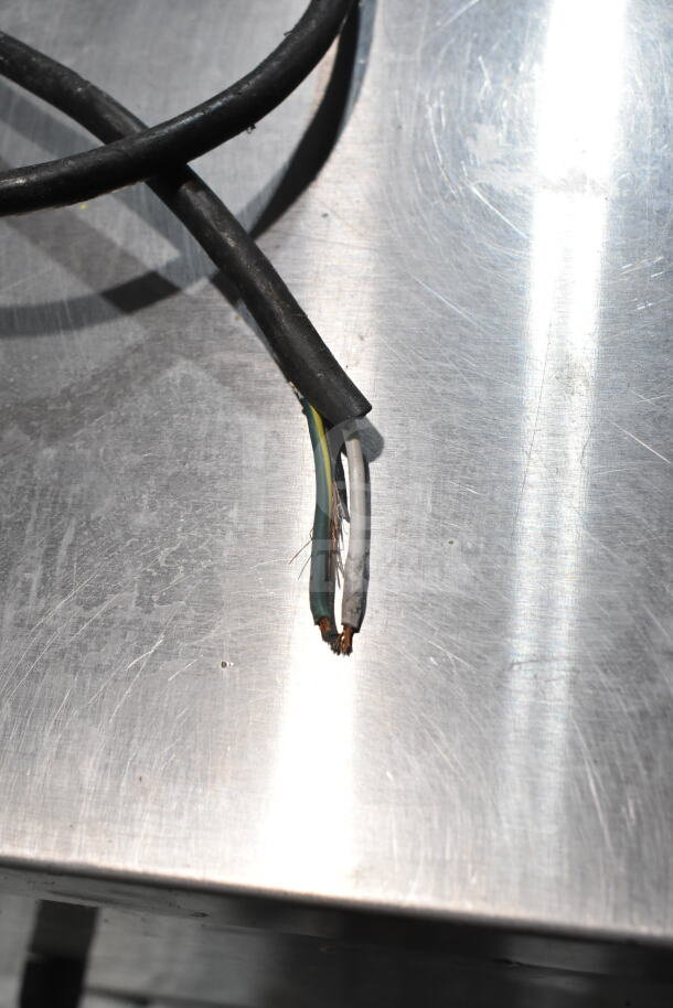 Close-up of damaged electrical wires on a True TSSU-48-08 commercial prep table, indicating repair needs.