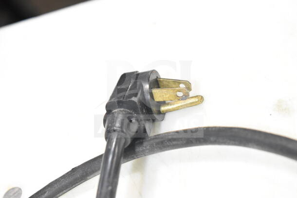 Close-up of a black electrical plug for the True TSSU-48-08 Commercial Sandwich Salad Prep Table.