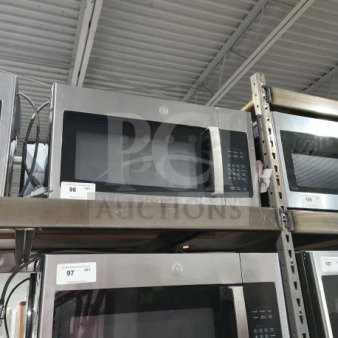 Brand new GE JVM3162RJSS 1.6 cu ft over-the-range microwave oven, with minor scratches and dents, on metal shelving.