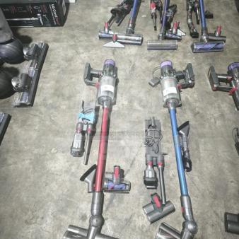 Dyson V11 Torque Drive PLUS vacuum, tested and working, cordless stick design, assorted colors, on a concrete floor.